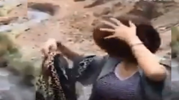 हिजाब उतारकर फेकती एक महिला